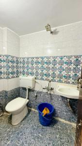 a bathroom with a toilet and a sink and a tub at Hotel Aashirwad in Indore