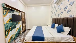 a hotel room with a bed with blue pillows at Hotel Aashirwad in Indore