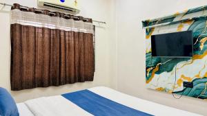a bedroom with a bed and a window at Hotel Aashirwad in Indore +25 photos