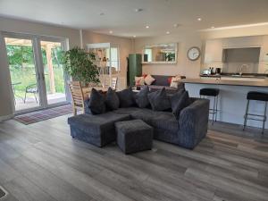a living room with a couch and a kitchen at Westmains Lodge in Callander