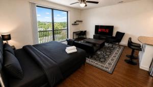 a living room with a black couch and a television at Luxe Nest King Studio Downtown 2B3 in Birmingham +10 photos