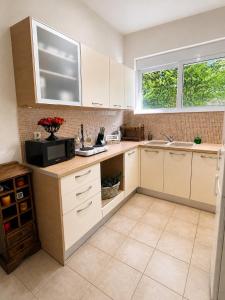 a kitchen with white cabinets and a sink at Villa Zose' luz in Káto Ássos