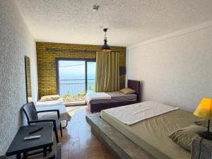 a bedroom with two beds and a view of the ocean at Alınca Elm Pansiyon in Fethiye +31 photos