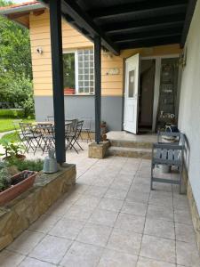 a patio with chairs and a bench on a house at Jázmin apartmanok in Pogány