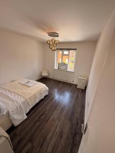 a bedroom with a bed and a chandelier at 3 Bedroom Central Apartment in Goodmayes