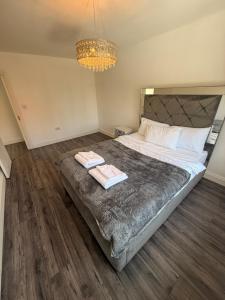 a bedroom with a large bed with two towels on it at 3 Bedroom Central Apartment in Goodmayes