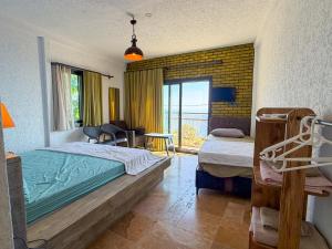 a bedroom with two beds and a view of the ocean at Alınca Elm Pansiyon in Fethiye