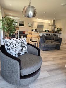 a living room with a couch and a chair at Westmains Lodge in Callander