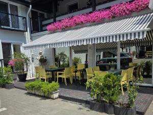 a restaurant with a table and chairs and purple flowers at Pensiunea Vila Chesa in Corunca