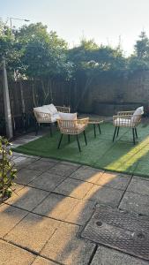 three benches sitting on the grass in a backyard at Riverside all for you in Kingston upon Thames +4 photos