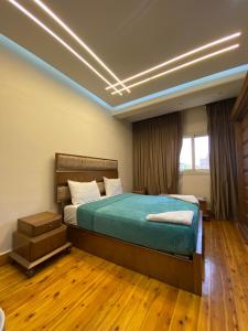 a bedroom with a bed in a room with wooden floors at Luxury Apartments - Downtown Cairo in Cairo