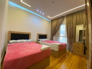 a bedroom with two beds and a mirror at Luxury Apartments - Downtown Cairo in Cairo