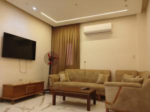 a living room with a couch and a flat screen tv at Luxury Apartments - Downtown Cairo in Cairo +6 photos
