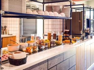 a kitchen with a bunch of food on a counter at ibis Budget Millau Viaduc in Millau