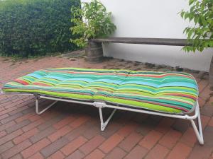 a bench sitting on a brick ground next to a building at Die blaue Hütte - Tiny House am Elberadweg in Seestermühe