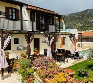 a patio with tables and chairs and a house at Charalambos Holiday Cottage in Kalavasos