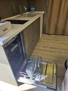 an open dishwasher in a kitchen next to a sink at Econest Aparan in Aparan