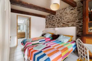 two beds in a room with a stone wall at Chambre de garel in Le Minihic-sur-Rance