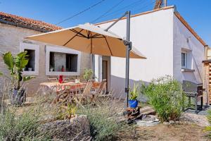 an umbrella in the garden of a house at Charmant appartement pour 4 in Saint-Jean-de-Liversay