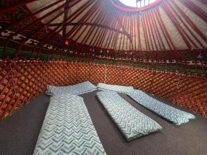 two beds in a yurt with a roof at Forest Yurt House Altyn Arashan in Mineralʼnyy Istochnik Altyn-Arasan