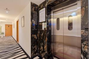 a hallway with a metal elevator with a sign on the wall at Treebo Premium Widlor Boutique with Swimming Pool in Mumbai