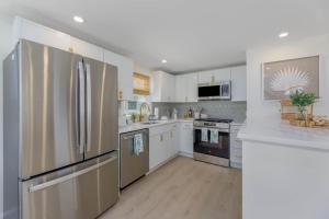 a kitchen with stainless steel appliances and white cabinets at Mermaid Lane #1 in Brighton Beach