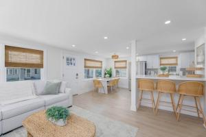 a white living room with a couch and a kitchen at Mermaid Lane #1 in Brighton Beach