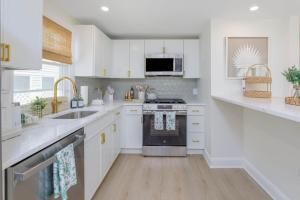 a kitchen with white cabinets and a stove top oven at Mermaid Lane #1 in Brighton Beach +14 photos