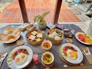 a table with eggs and bread and baskets of food at Ivy Cottage Ahangama in Ahangama