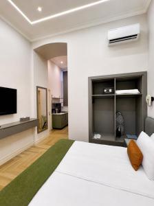 a bedroom with a white bed and a flat screen tv at Amara Boutique in Baku