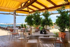a patio with tables and chairs and the ocean at The Palace Hotel, Sunny Day in Saints Constantine and Helena
