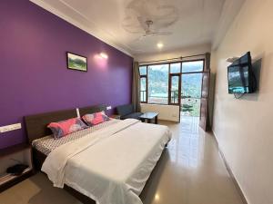 a bedroom with a bed and a purple wall at Hotel Backpacers Mcleodganj in McLeod Ganj