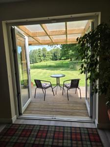 a patio with a table and chairs on a deck at Westmains Lodge in Callander +12 photos