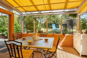 a dining room with a table and chairs and windows at Maison familiale Morgat, proche mer in Crozon