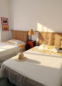 a bedroom with two beds with a hat on top at Il Mulino in Locri +17 photos