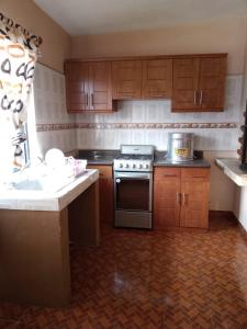a kitchen with wooden cabinets and a stove at Mayumi weekend accommodation in Cocoyoc +11 photos