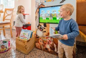 a young boy playing a video game in front of a tv at Hotel Nummerhof in Erding