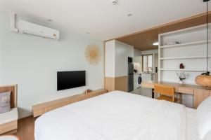 a bedroom with a white bed and a desk at Modern Studio at Wing Samui in Bophut