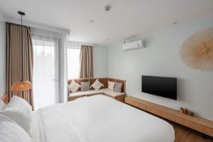 a white bedroom with a bed and a tv at Modern Studio at Wing Samui in Bophut +3 photos