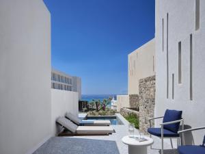 a balcony with chairs and a view of the ocean at Tinos Beach Hotel in Kionia