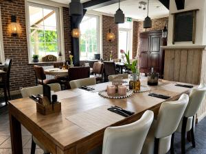 a dining room with a large wooden table and chairs at TETchalet met wellness tuin in Berkhout
