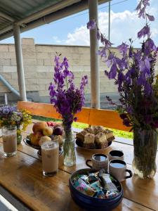 a wooden table with food and purple flowers on it at Arman's House Sevan in Sevan