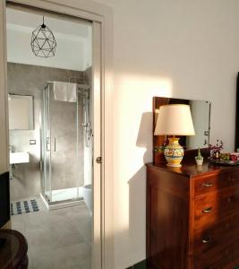 a bathroom with a shower and a lamp on a dresser at Il Mulino in Locri