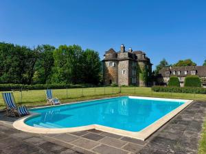 an estate with a swimming pool in front of a castle at Château de La Voulte in Marmanhac