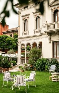 a group of chairs in front of a building at Villa Abbazia Relais & Chateaux in Follina