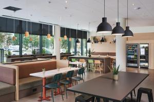 a restaurant with tables and chairs and windows at Première Classe Warsaw Airport in Warsaw