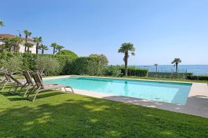 a swimming pool with two chairs and the ocean at Appartamenti Villa Andrea in Garda
