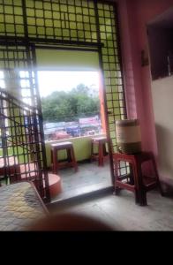 a room with a large window with a table and chairs at Sagar Hotel For Family in Mācherla