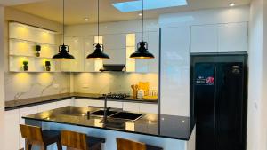 a kitchen with a counter with a sink and a refrigerator at Eden Collection Thalpe in Talpe
