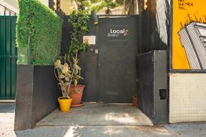 a black door with plants in front of a building at Localz House- Trumpeldor Beach in Tel Aviv